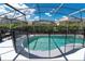 Screened-in pool with safety fence and shaded seating area at 8121 Fan Palm Way, Kissimmee, FL 34747
