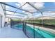 Screened-in pool with safety fence and a sunny patio with room for lounge chairs at 8121 Fan Palm Way, Kissimmee, FL 34747