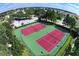 Aerial view of two community tennis courts surrounded by green landscaping and fencing at 8121 Fan Palm Way, Kissimmee, FL 34747