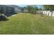 Expansive backyard with a large lawn, a concrete patio, mature trees, and a full privacy fence at 852 Adour Dr, Kissimmee, FL 34759