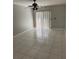Bright, empty room with neutral walls, tile flooring, a ceiling fan, and sliding glass doors at 852 Adour Dr, Kissimmee, FL 34759