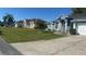 A street featuring similar homes with well-maintained lawns and landscaping in a suburban neighborhood at 852 Adour Dr, Kissimmee, FL 34759