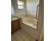 Bathroom with a large soaking tub, tiled surround, grab bar, and a vanity at 925 Derbyshire Dr, Kissimmee, FL 34758