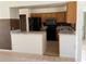 Well-equipped kitchen featuring wood cabinetry, black appliances, and a breakfast bar for additional seating and preparation space at 925 Derbyshire Dr, Kissimmee, FL 34758
