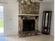 Cozy living room with a stone fireplace, a curio cabinet, tile flooring and sliding glass doors for backyard access at 925 Derbyshire Dr, Kissimmee, FL 34758
