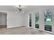Bright living room featuring large windows with views of the yard and contemporary light fixture at 9905 Nicoma Ln, Orlando, FL 32817