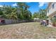 A view of the backyard with a partially covered patio, privacy fence, and some trees and plantings at 1526 Ferendina Dr, Deltona, FL 32725