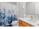 Bathroom features a modern sink, a blue-patterned shower curtain, and essential toiletries for a clean and functional space at 1526 Ferendina Dr, Deltona, FL 32725
