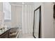 Bathroom features a large mirror, woven basket, and shower-tub combo behind a light white curtain at 1526 Ferendina Dr, Deltona, FL 32725