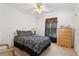 Bedroom with a queen size bed, ceiling fan, dark curtains, and a wooden dresser with ample storage space at 1526 Ferendina Dr, Deltona, FL 32725
