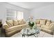 Comfortable living room featuring plush sofas and a glass coffee table at 1526 Ferendina Dr, Deltona, FL 32725