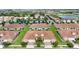 Beautiful aerial view of the townhouse community showcasing lush landscaping, a pool, and a serene lake at 1064 Quaker Ridge Ln, Davenport, FL 33896