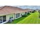 Well-maintained backyard featuring lush green grass, manicured hedges, and multiple patios at 1064 Quaker Ridge Ln, Davenport, FL 33896