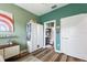 Bedroom that connects to bathroom with wood-look floors, green walls, and white wardrobe closet at 1064 Quaker Ridge Ln, Davenport, FL 33896