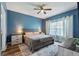 Inviting primary bedroom featuring a king-size bed, soft lighting, and calming blue walls at 1064 Quaker Ridge Ln, Davenport, FL 33896