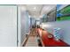Hallway with wood floors, light blue walls, golf-themed artwork and a red desk topped with golf balls at 1064 Quaker Ridge Ln, Davenport, FL 33896