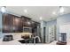 Well-lit kitchen with stainless steel appliances, white countertops, and dark wood cabinets at 1064 Quaker Ridge Ln, Davenport, FL 33896