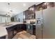 Modern kitchen features stainless steel appliances, dark cabinetry, and a large sink at 1064 Quaker Ridge Ln, Davenport, FL 33896