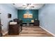 Spacious home office with wood floors, dark furniture, and a vibrant accent wall at 1064 Quaker Ridge Ln, Davenport, FL 33896