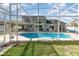 A view of the sparkling blue pool with screened enclosure and patio seating at 108 Honeywood Ct, Kissimmee, FL 34743