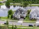 Beautiful home with lush landscaping, a paver driveway, and a serene lake view featuring a fountain at 10950 Belle Maisons Dr, Orlando, FL 32832