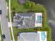Aerial shot of a property highlighting its pool, landscaping, and proximity to a beautiful pond at 10950 Belle Maisons Dr, Orlando, FL 32832