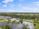 Scenic aerial view of a community with lush green landscaping and a tranquil pond with fountains at 10950 Belle Maisons Dr, Orlando, FL 32832