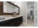 Bathroom with double sink vanity, granite countertop, and wood-framed mirror at 10950 Belle Maisons Dr, Orlando, FL 32832