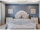 Inviting bedroom showcasing stylish decor, a chandelier, and blue accent wall at 10950 Belle Maisons Dr, Orlando, FL 32832