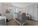 Charming Bedroom with decorative crib, chandelier, and elegant window treatments at 10950 Belle Maisons Dr, Orlando, FL 32832
