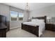 Comfortable bedroom features a wooden bed frame, bedside tables, and a large window at 10950 Belle Maisons Dr, Orlando, FL 32832