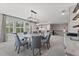 Open-concept dining area with a modern chandelier and plentiful natural light through the windows at 10950 Belle Maisons Dr, Orlando, FL 32832