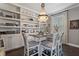 Dining room with decorative chandelier, full shelves and chairs with decorative trim at 10950 Belle Maisons Dr, Orlando, FL 32832