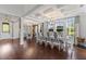 Spacious dining room showcasing hardwood floors, a coffered ceiling, and large windows with views of the outside at 10950 Belle Maisons Dr, Orlando, FL 32832