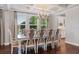 Elegant dining room with a coffered ceiling, chandelier, and large windows providing ample natural light at 10950 Belle Maisons Dr, Orlando, FL 32832