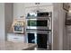 Stainless steel oven and microwave nestled in white cabinets, complete with countertop appliances at 10950 Belle Maisons Dr, Orlando, FL 32832
