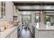Bright white kitchen with stainless steel appliances and dark wood flooring open to dining room at 10950 Belle Maisons Dr, Orlando, FL 32832