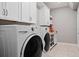 Bright laundry room featuring modern appliances and ample storage at 10950 Belle Maisons Dr, Orlando, FL 32832