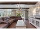 Living room with stone accent wall, beamed ceiling, and backyard view at 10950 Belle Maisons Dr, Orlando, FL 32832