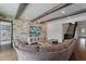 Open living area with stone wall, cozy seating, and view to staircase at 10950 Belle Maisons Dr, Orlando, FL 32832