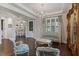 Elegant living room with stylish seating, hardwood floors, a chandelier, and an ornate mirror at 10950 Belle Maisons Dr, Orlando, FL 32832