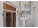 Unique powder room with pedestal sink and quirky cabinet at 10950 Belle Maisons Dr, Orlando, FL 32832