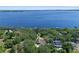 Aerial view of a lakeside home surrounded by lush greenery at 11951 Elbert St, Clermont, FL 34711