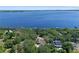 Aerial view of a lakeside home surrounded by lush greenery at 11951 Elbert St, Clermont, FL 34711