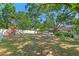 Expansive backyard featuring mature trees, a white fence, and a play area for children at 11951 Elbert St, Clermont, FL 34711
