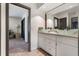 Bright bathroom featuring double vessel sinks atop a granite countertop and wood look tile floors at 11951 Elbert St, Clermont, FL 34711