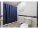 Bright bathroom with a blue shower curtain, white toilet, and decorative tile accents at 11951 Elbert St, Clermont, FL 34711