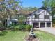 Charming house featuring a three-car garage, landscaped yard with fountain, and mature trees at 11951 Elbert St, Clermont, FL 34711