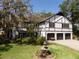 Charming house featuring a three-car garage, landscaped yard with fountain, and mature trees at 11951 Elbert St, Clermont, FL 34711