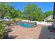 Fenced in pool area with brick patio and a glimpse of the large backyard with playground at 11951 Elbert St, Clermont, FL 34711